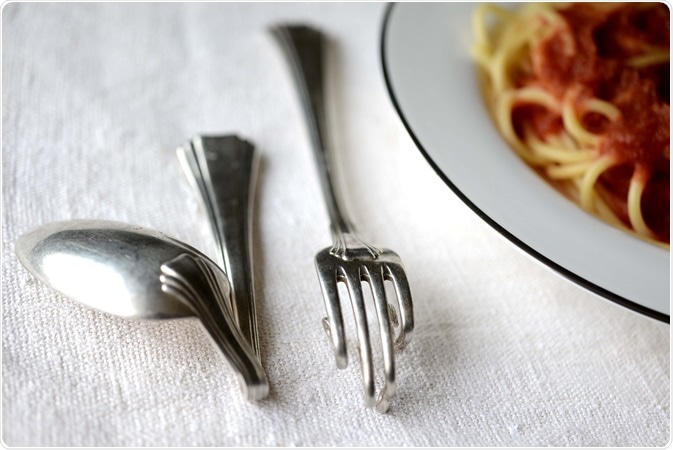 Cranked spoon and fork with a spaghetti dish.